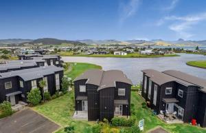 an aerial view of a row of houses next to a river at Charming Lakeview Golf Villa in Matarangi
