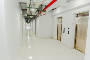 an empty corridor in a building with white walls and ceilings at Aurora Rooms Riverdale in Rawasuren +34 photos