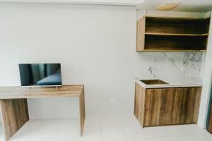 a kitchen with a desk and a tv on a wall at Aurora Rooms Riverdale in Rawasuren