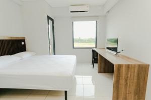 a white bedroom with a bed and a desk at Aurora Rooms Riverdale in Rawasuren