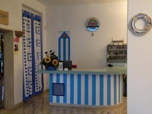 a shop with a blue and white counter in a room at Hotel Lux in Cesenatico