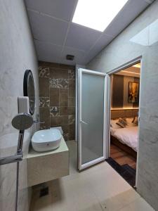a bathroom with a shower and a sink and a bed at Hotel Fortune in Ayodhya