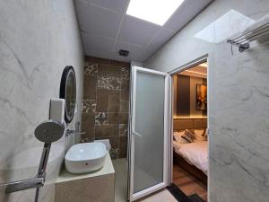 a bathroom with a shower and a sink and a bedroom at Hotel Fortune in Ayodhya