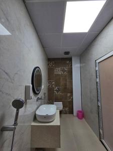 a bathroom with a toilet and a sink and a mirror at Hotel Fortune in Ayodhya
