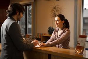 a man and a woman shaking hands at a counter at Motel Du Chevalier in Gatineau +21 photos