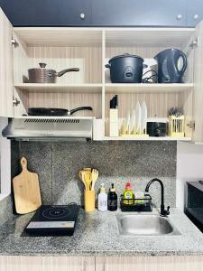 a kitchen counter with a sink and a stove at Eclectic Haven at Urban Deca Homes - 2 bedroom micro unit near SM City , IT Park & Ayala Mall - N0 PARKING in Mandaue City +5 photos