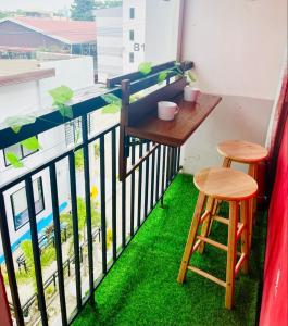 a small balcony with a table and two stools at Eclectic Haven at Urban Deca Homes - 2 bedroom micro unit near SM City , IT Park & Ayala Mall - N0 PARKING in Mandaue City