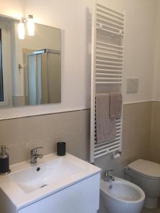 a bathroom with a sink and a toilet and a mirror at Casa Mama in Rho