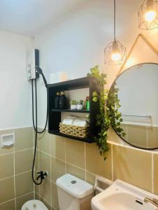 a bathroom with a mirror and a toilet and a sink at Eclectic Haven at Urban Deca Homes - 2 bedroom micro unit near SM City , IT Park & Ayala Mall - N0 PARKING in Mandaue City