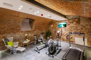 a gym with several exercise equipment in a brick wall at Adele Boutique Hotel in Pécs