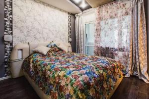 モスクワにあるGoodSleep Kirovogradskaya 24のベッドルーム1室(カラフルな掛け布団、窓付)