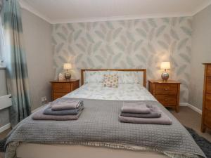 a bedroom with a bed with towels on it at The Chalet in Egremont