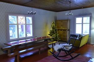 a living room with a piano and a christmas tree at Idyllic Peltola in Ranua