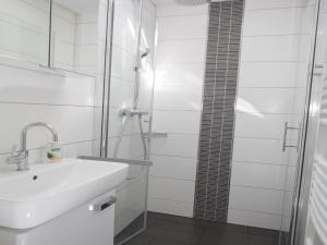 a bathroom with a sink and a shower at Sint Maartenszee Renovated Family Retreat in Sint Maartenszee +24 photos