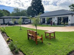 two park benches and a table in a yard at Rabi’s guesthouse in Mahikeng