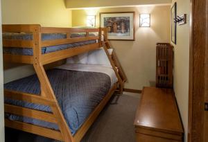 2 Etagenbetten in einem kleinen Zimmer mit einem Tisch in der Unterkunft 3413 - One Bedroom Den Standard Powderhorn Lodge condo in Solitude