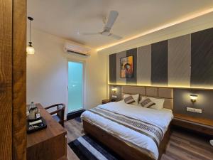 a bedroom with a bed and a desk and a window at Hotel Fortune in Ayodhya