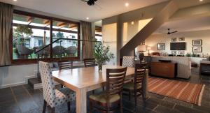 a dining room with a wooden table and chairs at Klein Welmoed Luxury Guest House in Stellenbosch