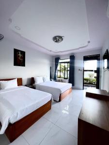 a hotel room with two beds and a television at Khách sạn Thanh Tâm in Nha Trang