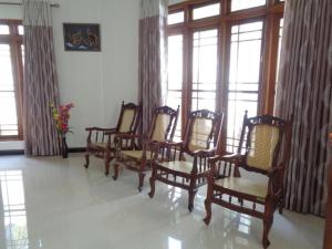- un groupe de chaises dans une chambre avec fenêtres dans l'établissement Riverdale holiday Inn, à Kanduruwela 3 autres photos