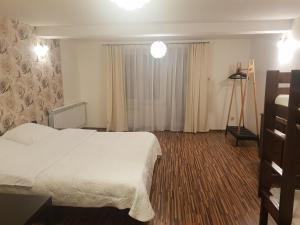 a hotel room with a white bed and a window at Willa Rodzinna in Tylicz