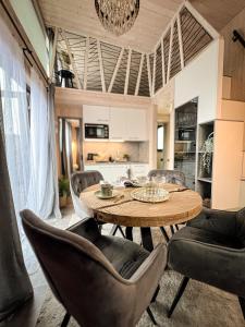 a dining room with a wooden table and chairs at Villa Lakstīgalas Charm in Skrīveri