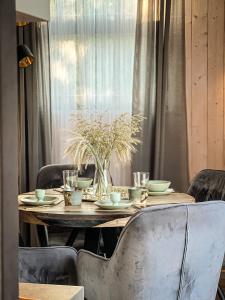 a wooden table with plates and bowls on top at Villa Lakstīgalas Charm in Skrīveri +47 photos