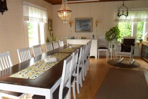 a dining room with a long table and white chairs at Laiskan Kartano in Härmä