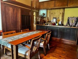 una cucina con tavolo in legno, sedie e bancone di 六弥苑 a Matsuzaki