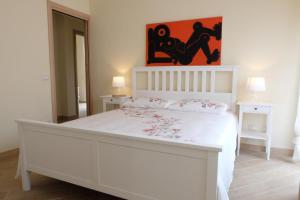 ローマにあるTerrazza sul Parcoの白いベッドルーム(花の飾られた白いベッド付)