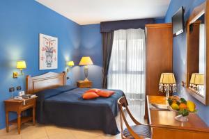 Schlafzimmer mit blauen Wänden und einem Bett mit orangefarbenen Kissen in der Unterkunft Ulisse Deluxe Hostel in Sorrent