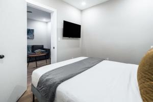 um quarto com uma cama e uma TV na parede em Prestige Brickell Miami Suite em Miami