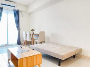 芝卡朗Good Place and Elegant 3BR Meikarta Apartment By Travelio的一间卧室，配有一张床和一张桌子和椅子