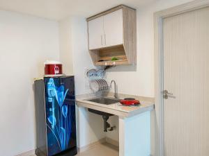 芝卡朗Good Place and Elegant 3BR Meikarta Apartment By Travelio的一个小厨房，里面有水槽和冰箱