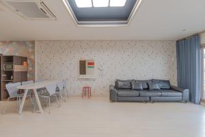 a living room with a couch and a table at Jeju Sol Pension Jeju Sunrise from the Room in Chung-dong