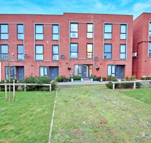 a red brick building with a yard in front of it at Modern Spacious 3 Bedroom House in Hertfordshire in Borehamwood