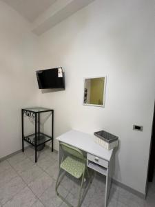 Una mesa blanca con una silla y un espejo en la pared. en La casetta di lalla, en Civitavecchia 35 fotos más