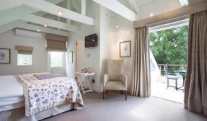 a bedroom with a bed and a chair and a balcony at Klein Welmoed Luxury Guest House in Stellenbosch +137 photos