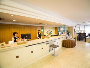 two women standing at a counter in a kitchen at South Breeze Hotel Kochi Kaigetsu in Kochi