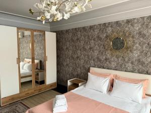 a bedroom with a bed and a mirror at TURAN SEMEY GRAND HOTEL in Semey
