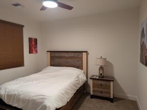 a bedroom with a bed and a table with a lamp at Mountain Melody Hideaway in Reno