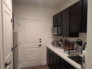a kitchen with black cabinets and a white door at Mountain Melody Hideaway in Reno +6 photos
