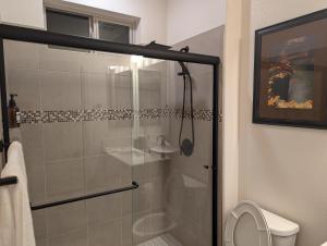 a bathroom with a glass shower with a toilet at Mountain Melody Hideaway in Reno