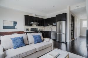 a living room with a white couch and a kitchen at Blueground Burlingame ac wd nr park SFO-1791 in San Francisco