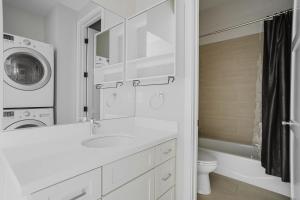 a white bathroom with a sink and a washing machine at Blueground Burlingame ac wd nr park SFO-1791 in San Francisco +19 photos
