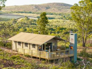 a building with a roof on the side of a hill at AfriCamps at Milorho in Rustenburg