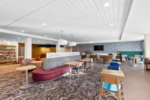 a lobby with a couch and tables and chairs at Home2 Suites By Hilton Hendersonville in Hendersonville