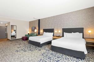 a hotel room with two beds and a couch at Home2 Suites By Hilton Hendersonville in Hendersonville +22 photos