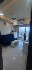 a living room with a blue couch and a table at Cozy Vibes in Navi Mumbai