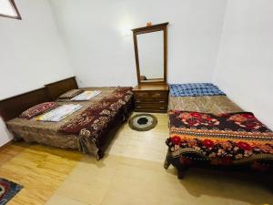a bedroom with two beds and a mirror on the wall at New Eagle Best Inn in Haputale